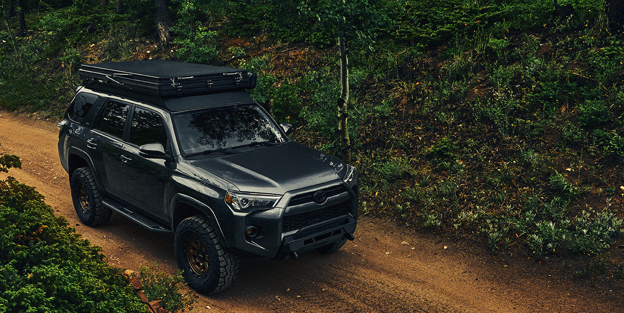Toyota 4Runner equipped with Body Armor 4x4 accessories on a forest trail